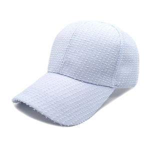 Close-up of light blue baseball cap featuring a unique frayed tweed texture and classic design