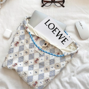 Detailed top view of a quilted blue argyle laptop bag with cute bear patterns and handles