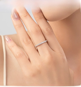 Gros plan d'une bague éternité en argent 925 avec zircons brillants portée au doigt