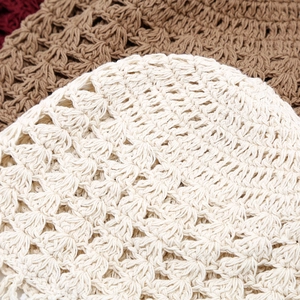 Detailed view of handmade crochet hollow knit beanies with floral patterns and tassels