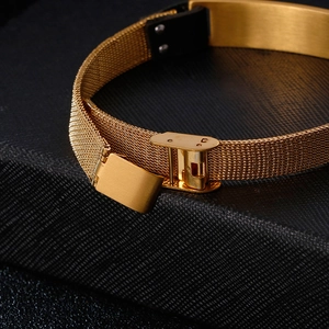 Minimalist gold mesh chain bracelet with folding clasp for men on black textured surface