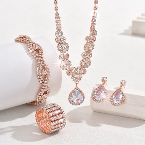Detailed view of rose gold jewelry set with teardrop crystals on geometric props