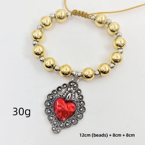 Detail view of vintage copper bead bracelet with red heart charm and size specifications