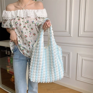 Close-up of blue and white striped puff bubble texture on a large tote shoulder bag