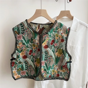 Close-up of ethnic embroidered floral patterns on short vest collar and shoulder wrap