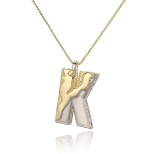 Detailed shot of two-tone letter K pendant with irregular texture on gold chain