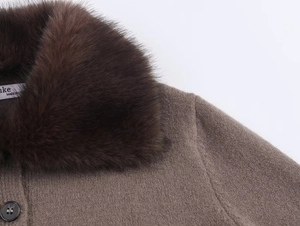 Détail du cardigan marron avec un col en fausse fourrure et des boutons foncés
