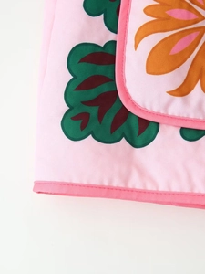 Detailed macro view of pink floral print on premium cotton jacket with fine hem stitching