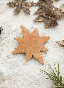 Close-up of snowflake wooden ornament with natural bark texture on artificial snow background
