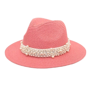 Detailed view of a pink woven fedora hat featuring elegant white pearl bead decorations
