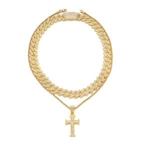 Close-up of gold iced out Cuban link chain and diamond cross pendant necklace