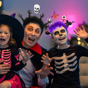 Family wearing Halloween skeleton costumes and themed headbands with ghosts and bats