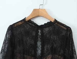 Détail de la dentelle florale noire transparente et broderie sur un haut à manches