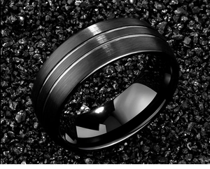 Macro shot of men's black tungsten ring featuring brushed metal finish and silver grooves