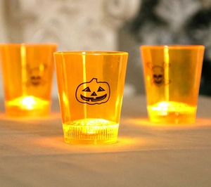 Close-up of three Halloween LED light cups with pumpkin and skull prints for party decor