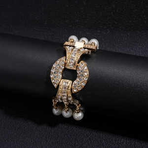 Macro detail of luxury multi-layer gold bracelet with crystals and white pearls on black