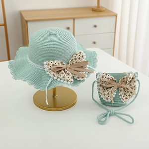 Dettaglio del set cappello di paglia verde menta e borsa a tracolla con pizzo e fiocco