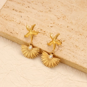 Detailed close-up of summer starfish shell earrings with white pearl on stone