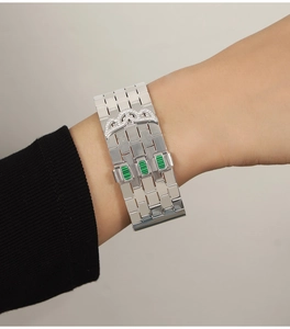 Detail of silver watchband style bangle with green striped accents and pavé diamond wavy design