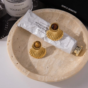 Flat-lay detail van 18K vergulde waaiervormige oorbellen met tijgeroog edelstenen