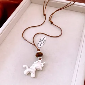 Vue détaillée d'un pendentif licorne en argent mat avec perle brune sur cordon tressé