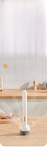 Detail of liquid-dispensing kitchen brush with adjustable handle and soft bristles