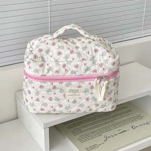 Detailed view of white quilted makeup bag featuring pink hearts and grey rabbit print