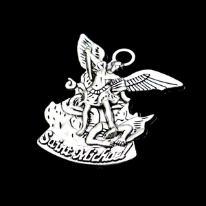 Macro shot of silver Saint Michael pendant showing intricate details on black background