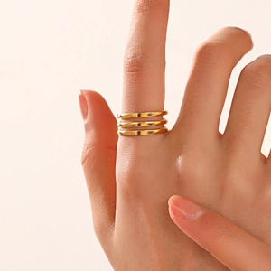 Minimalist golden triple-layered stainless steel open ring with a matte finish on model
