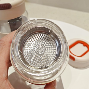 Detailed macro view of the SUS 304 stainless steel tea infuser and double-wall glass rim