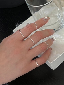 Detail of five silver textured stackable rings with irregular handmade hammer finish