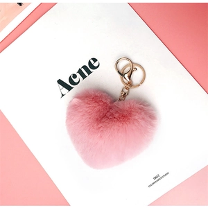 Close-up of a plush pink heart-shaped keychain with gold metal ring and lobster clasp