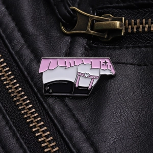 Gros plan d'un badge en émail rose de style anime sur une veste en cuir noir