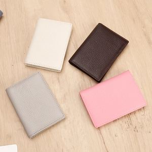 Flat lay of litchi grain leather card holders in white, brown, grey, and pink colors