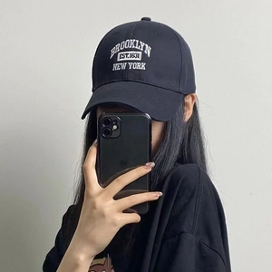Black cotton baseball cap featuring white Brooklyn embroidery on a classic curved brim hat
