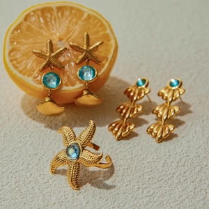 Golden starfish ring and earrings set with blue gemstones and leaf designs