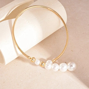 Detailed macro view of vintage gold metal choker featuring gradient faux pearls on stone