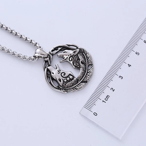 Détail macro du collier pendentif loup viking et plume argentée avec règle de mesure