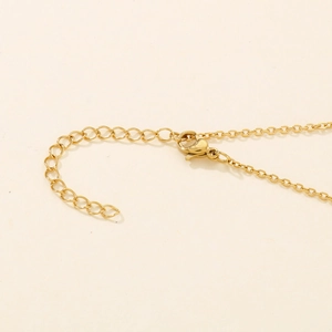 Close-up of gold smiley necklace with lobster clasp and adjustable extension chain