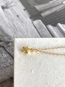 Detailed macro view of the gold star pendant necklace featuring a sparkling zircon stone
