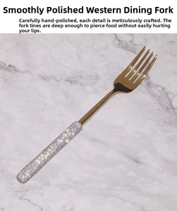 Detail of luxury gold dessert fork with white rhinestone handle and mirror finish