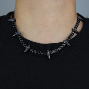 Close-up of a 5mm black tennis chain featuring sharp spike pendants on a male model neck