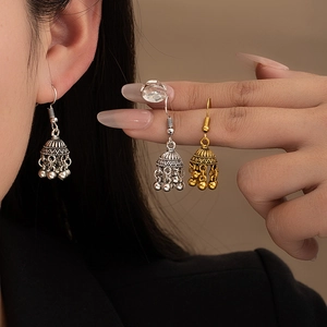 Detail of vintage bohemian bell earrings with beads fringe on a model for scale