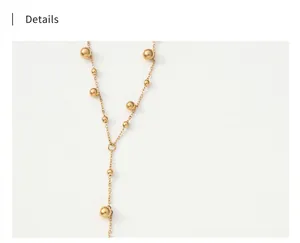 Macro shot of long gold-toned tassel necklace featuring polished round beads on the chain