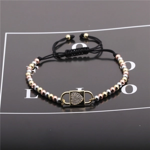 Detail view of adjustable black rope bracelet with colorful metal beads and heart lock charm