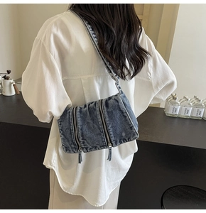 Modèle portant un grand sac cabas en denim bleu vintage avec fermeture éclair en métal