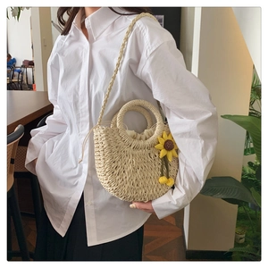 Detail der beige Strohumhängetasche mit Sonnenblumenanhänger und Kordelzugfutter