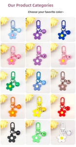 Matrix display of colorful flower-shaped metal keychains with matching bells in 15 vibrant hues
