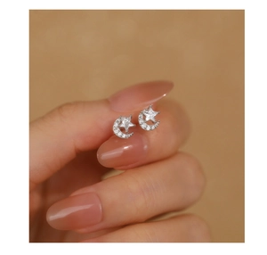 Close-up of S925 sterling silver moon and star earrings with sparkling zircon on a model