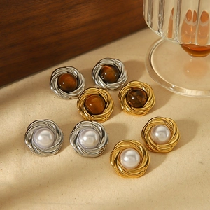 Détail de boucles d'oreilles vintage en or 18k et ambre sur fond de tissu beige élégant